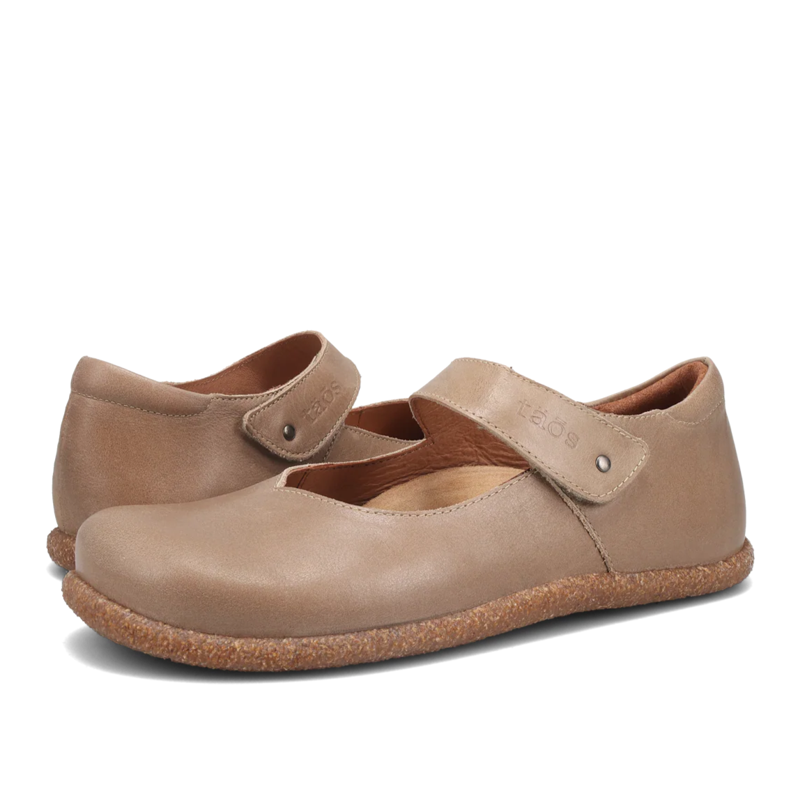 Pair of beige shoes with a strap on a white background