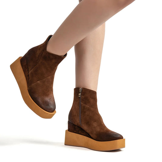 Brown platform ankle boots on a white background