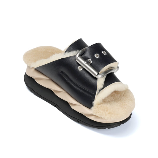 Black sandal with beige fur lining on a white background