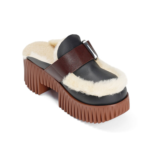 Black and brown platform clog with shearling lining on a white background