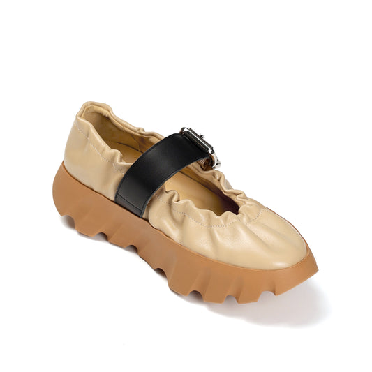 Beige shoe with a black strap on a white background
