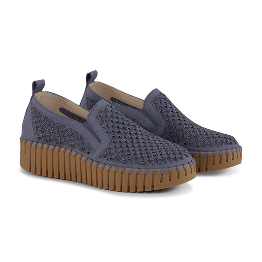 Pair of blue slip-on shoes with brown soles on a white background